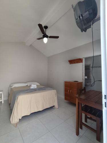 um quarto com uma cama e uma ventoinha de tecto em Vila da Praça Pousada em Capitólio