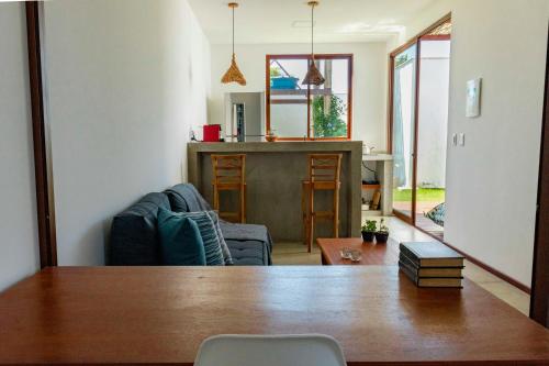 a living room with a table and a kitchen at Vila de Charme in São Miguel do Gostoso