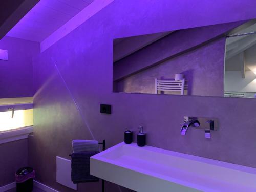 a purple bathroom with a sink and a mirror at Villa Primodì in Bologna