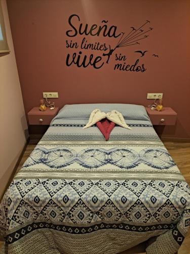 um quarto com uma cama com uma placa na parede em Casa Justa em Castrelo de Miño