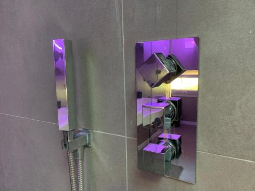 a mirror in a bathroom with purple lights at Villa Primodì in Bologna
