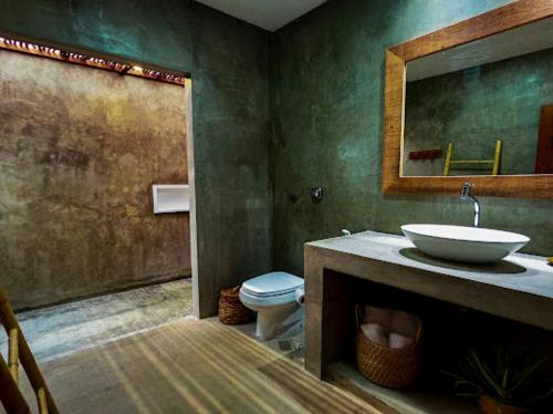 a bathroom with a sink and a toilet at Vila de Charme in São Miguel do Gostoso