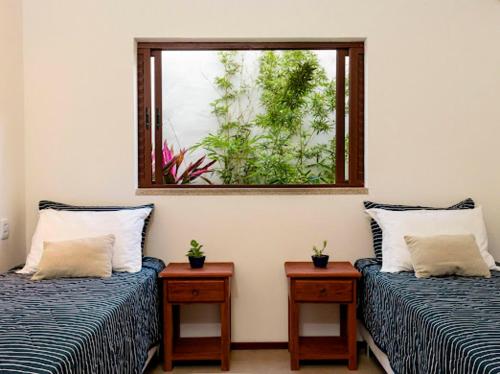 a room with two beds and a window at Vila de Charme in São Miguel do Gostoso