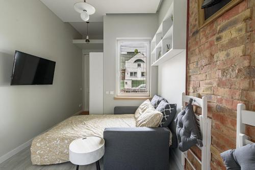 ein kleines Schlafzimmer mit einem Bett und einer Ziegelwand in der Unterkunft Angel House Vilnius, 46 in Vilnius