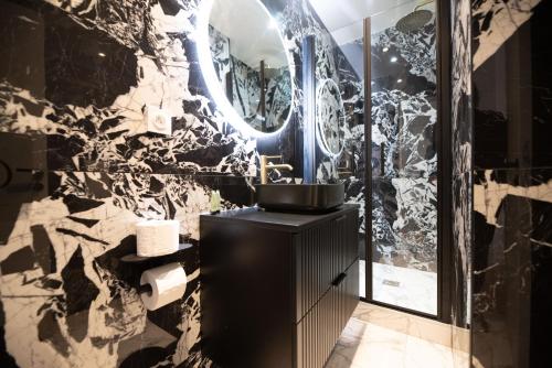 een badkamer met een zwarte wastafel en een spiegel bij Lovely Apartment close to Eiffel Tower in Parijs