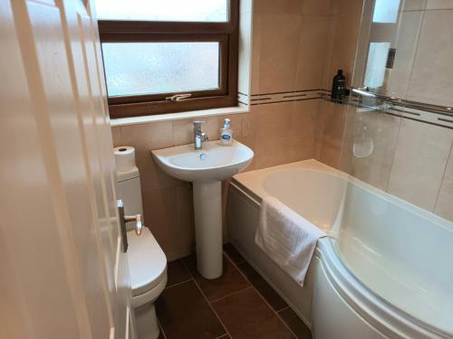 uma casa de banho com um lavatório, um WC e uma banheira em 3 bedroom house em Barrow in Furness