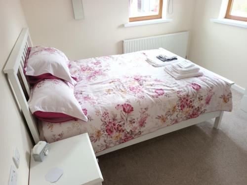 um quarto com uma cama com uma colcha e almofadas florais em 3 bedroom house em Barrow in Furness
