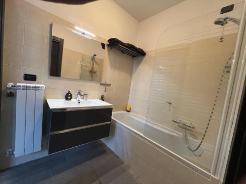 a bathroom with a sink and a shower and a tub at Luxury Apartment Lake Como in Acquaseria