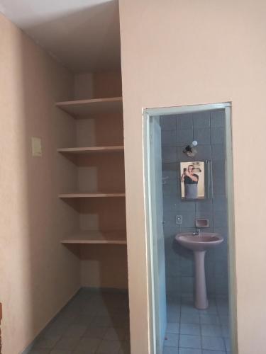 uma casa de banho com lavatório, WC e prateleiras em Kitnets para temporada em Uberaba