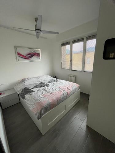 a white bedroom with a bed and two windows at Luxury Apartment Lake Como in Acquaseria