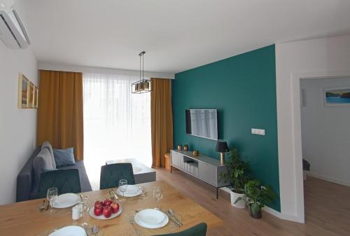 ein Wohnzimmer mit einem Tisch und einer blauen Wand in der Unterkunft Apartament nr15 z parkingiem podziemnym in Toruń