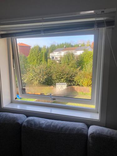 a window with a couch looking out at a house at Sleep with the stars in Oslo