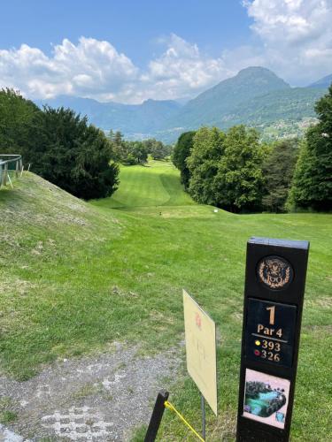 a sign in a field with a view of a golf course at Luxury Apartment Lake Como in Acquaseria