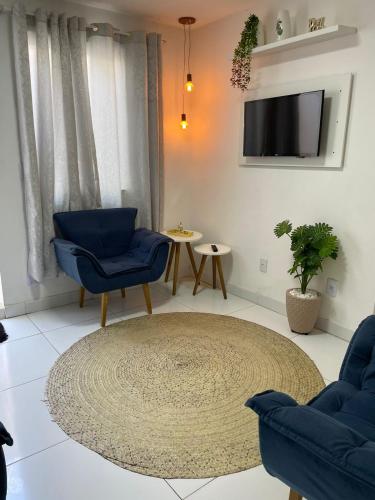 uma sala de estar com duas cadeiras azuis e um tapete em Pousada hostel praia itapua em Salvador