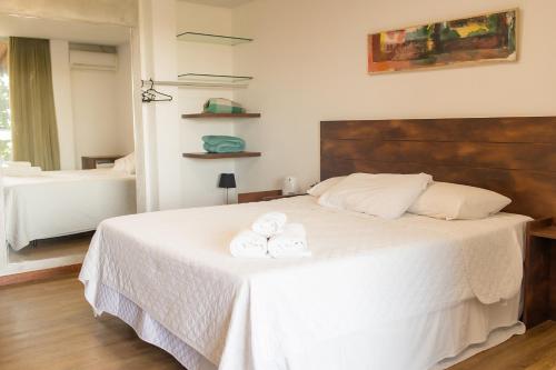 a bedroom with a bed with two towels on it at Orquídea Café in Guarapari