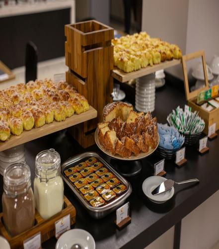 a buffet of pastries and other desserts on a counter at Comfort Hotel Presidente Prudente in Presidente Prudente