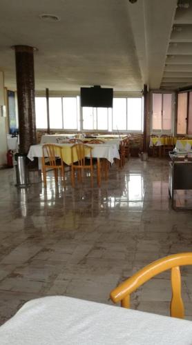 a dining room with tables and chairs and a flat screen tv at Hotel minia in Minya