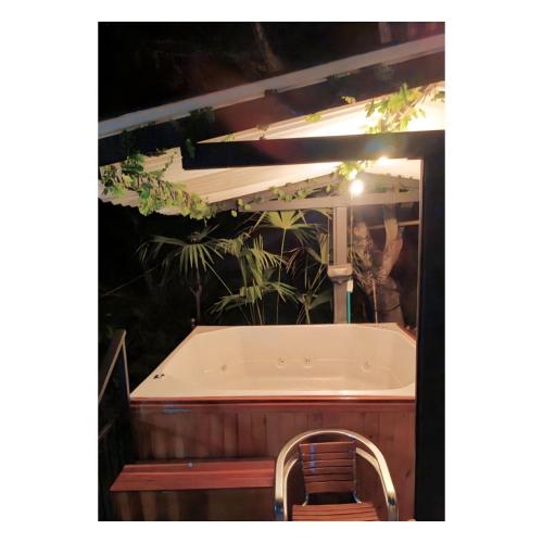 a bath tub with a chair in front of it at Cabaña El Mirador - La Mesa in La Mesa