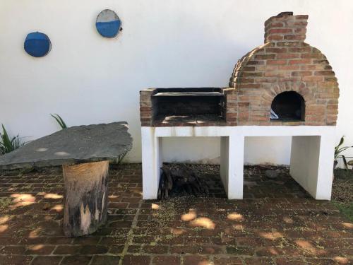 un horno de ladrillo con una mesa y un banco en Almendra Residential, en Cabarete