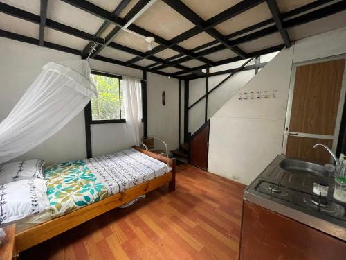 Habitación con cama y cocina con fregadero en Cabaña El Mirador - La Mesa, en La Mesa