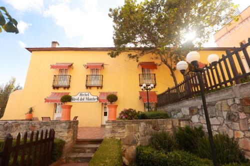 a yellow building with a fence in front of it at Hotel Real Del Monte in Mineral del Monte