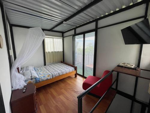 a bedroom with a bed and a desk and a window at Cabaña El Mirador - La Mesa in La Mesa