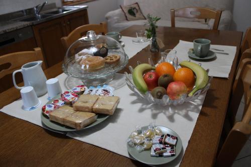 uma mesa com uma taça de fruta e um prato de comida em B&B Ca' Teonghio em Orgiano