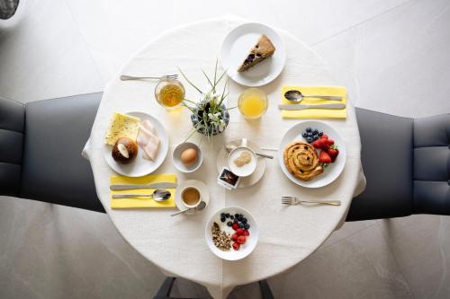 a white table with breakfast foods and drinks on it at B&B Relais Dolomiti in Bedollo