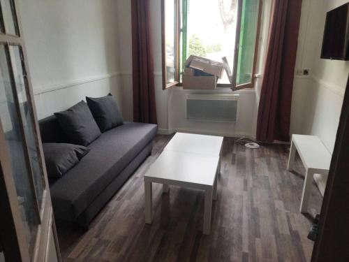 a living room with a couch and a table at BudgetBnb 280, studio La Seyne rdc in La Seyne-sur-Mer