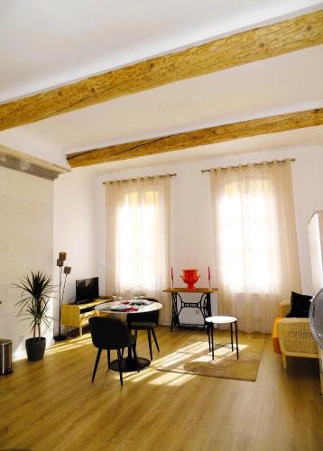 un salon avec un canapé et une table dans l'établissement AUGUSTINS FOUNTAIN Studio Cosy AIX Centre Historique à 3 minutes de COURS MIRABEAU -WIFI-SMART TV-RUE CALME, à Aix-en-Provence