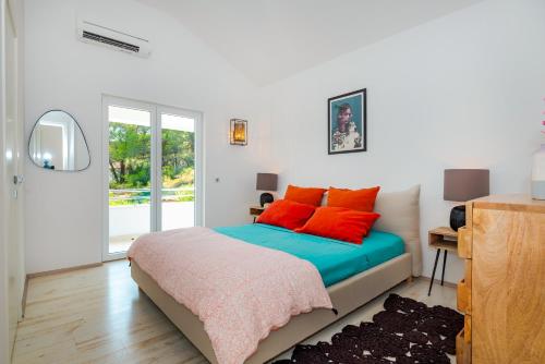 普路維奇盧卡的住宿－Villa Marceline，一间卧室配有一张带红色枕头的床