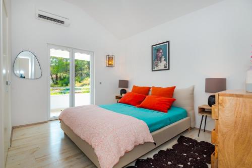 a bedroom with a bed with red pillows on it at Villa Marceline in Prvić Luka