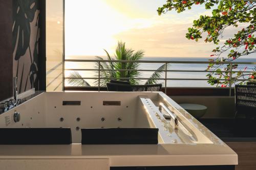 a bathroom with a bath tub with a view of the ocean at Le Tahiti by Pearl Resorts in Papeete