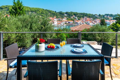 a blue table with plates of food on a balcony at Villa Marceline in Prvić Luka