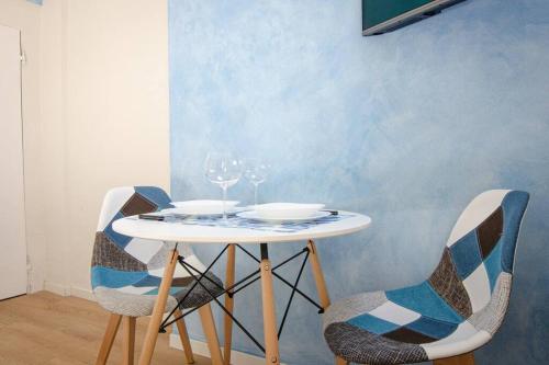 un tavolo bianco con sedie e bicchieri da vino sopra di Blue Studio a Bologna