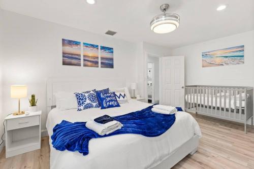 um quarto com uma cama com um cobertor azul em Paradise King Bed Crib Game Room Hot Tub 7m Beach Washer Dryer em Deerfield Beach