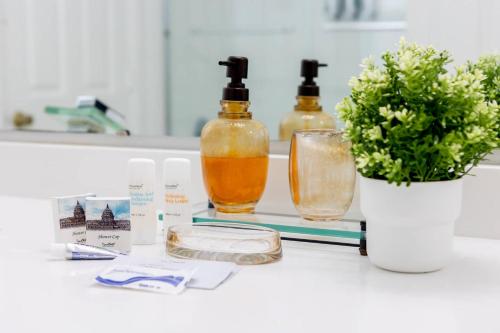 a bathroom counter with two bottles of essential oils and a plant at 4br House w Perfect Location Pool and Much More in Kissimmee