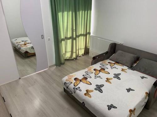a bedroom with a bed with butterflies on it at Lovely 1-room apartment in Popeşti-Leordeni