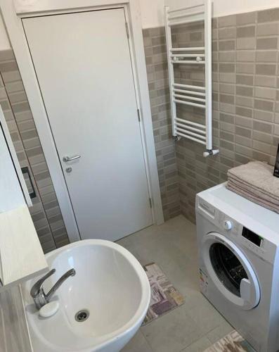 a bathroom with a sink and a washing machine at Lovely 1-room apartment self check-in in Popeşti-Leordeni