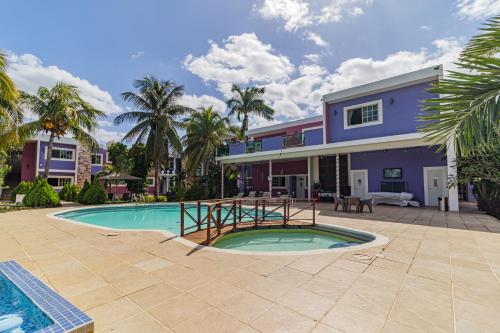a house with a swimming pool in front of a house at Hotel Suites Paraíso in Mérida