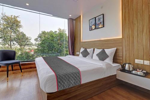 a bedroom with a bed and a large window at Super OYO Townhouse 1232 White Sand in Dehradun