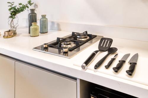a kitchen counter with a stove and utensils at Beach House by ULIV in Ensenada
