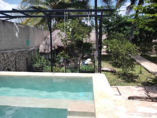 a small swimming pool with a thatch roof at Hotel y Museo Aldea Maya Toktli Orígenes - Casa Maya Toh - Alberca, Wifi Starlink, Tour Museo in Izamal
