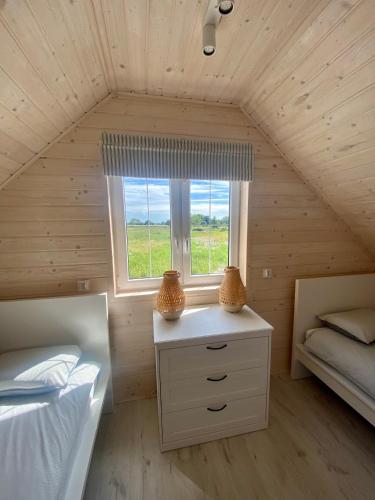 a small bedroom with two beds and a window at DESTINO wakacyjne domki-dwa podgrzewane baseny-drink bar in Mielno