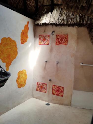 a corner of a room with red and yellow designs on the wall at Hotel y Museo Aldea Maya Toktli Orígenes - Casa Maya Toh - Alberca, Wifi Starlink, Tour Museo in Izamal