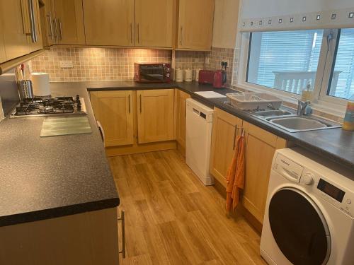 a kitchen with a sink and a stove top oven at Lanarkshire entire house sleeps 6, contractors, trade stays in Kilsyth