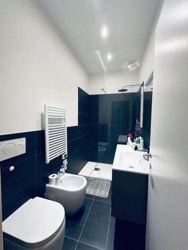 baño azul y blanco con aseo y lavamanos en Grazioso&strategico monolocale, en Bolonia