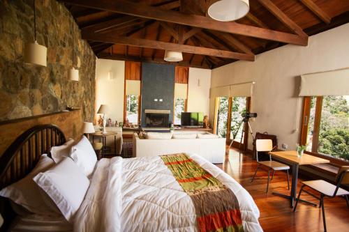 a bedroom with a bed and a living room at Chalé Leopoldo-Nas Nuvens in São Bento do Sapucaí