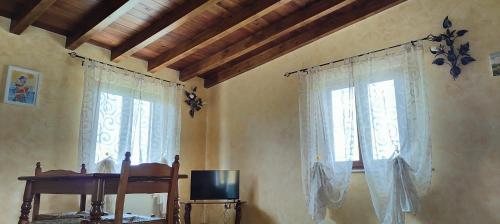 a living room with two windows and a television at B&B Camera delle Camelie in Palestrina