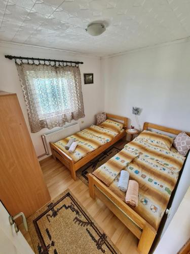 a bedroom with four beds and a window at Vikendica Jovanovic in Bajina Bašta